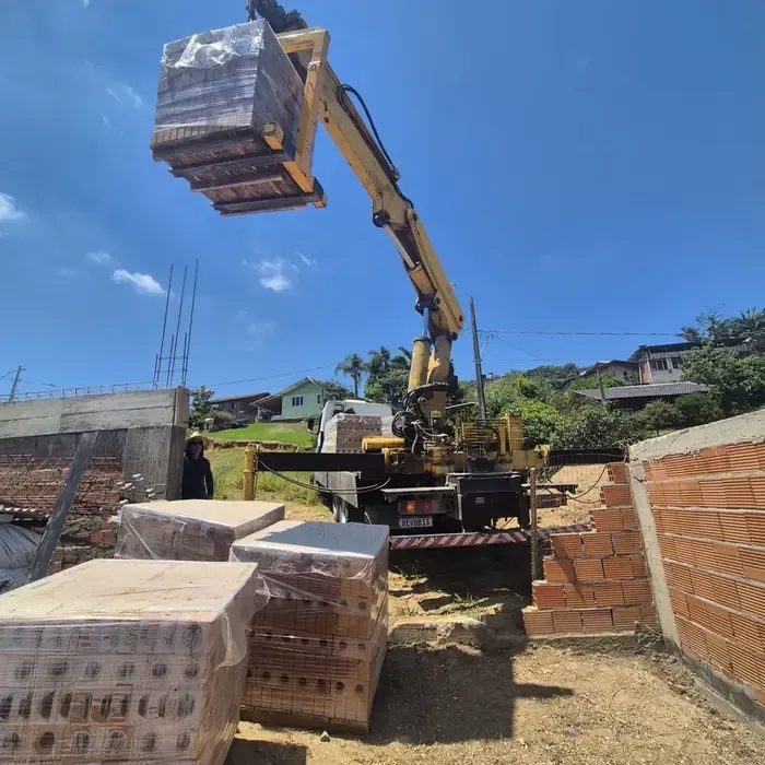 Entrega de tijolos com caminhão munck na obra