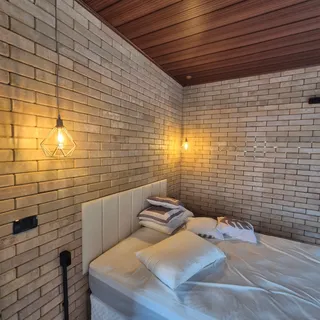 Quarto com parede de tijolo ecológico aparente